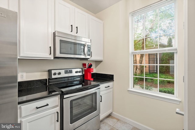 42432 Hollyhock Ter Unit 101, Brambleton, VA 20148 - kitchen with stainless steel appliances, plenty of natural light, dark countertops, and white cabinets
