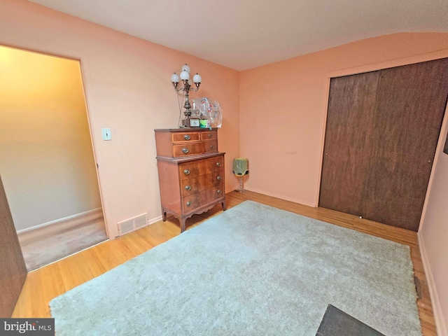 bedroom featuring wood finished floors, a closet, and baseboards