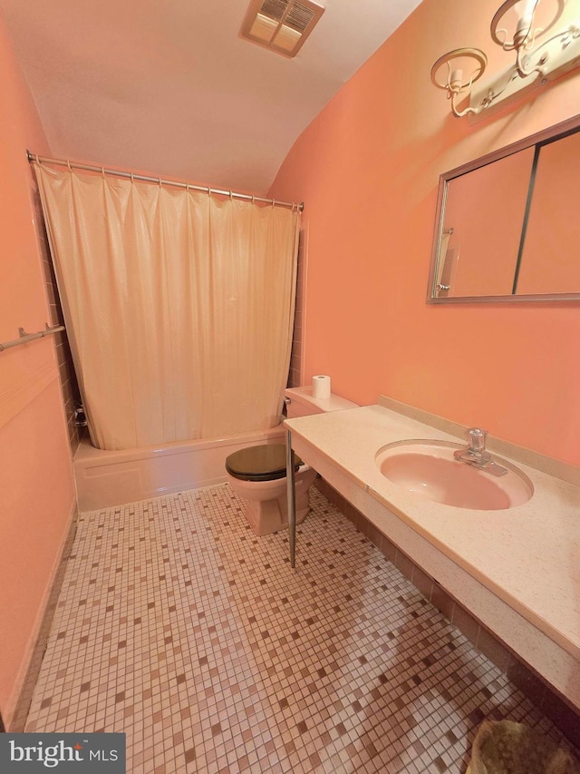 bathroom with toilet, vaulted ceiling, vanity, and shower / tub combo