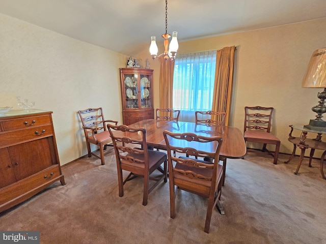 dining space with carpet, a chandelier, and lofted ceiling