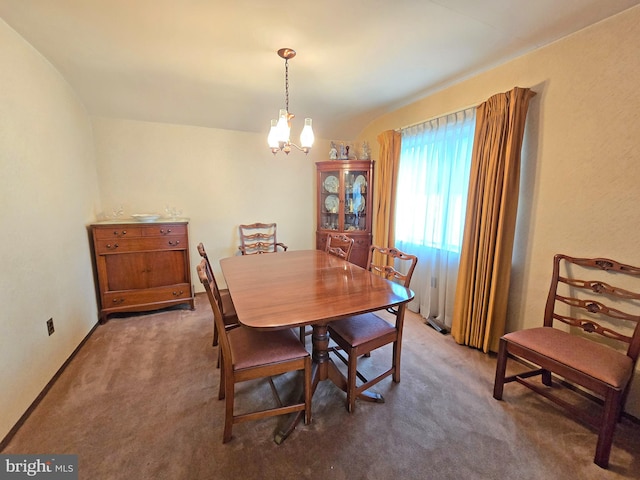 dining space with carpet floors and a chandelier