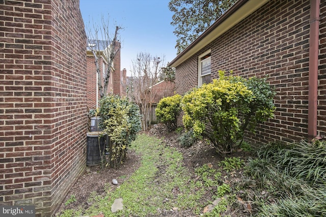 view of yard featuring central AC and fence