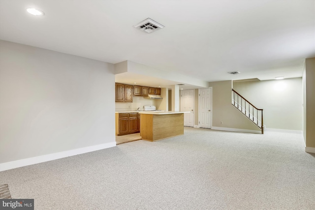 kitchen with baseboards, light countertops, brown cabinets, light carpet, and recessed lighting