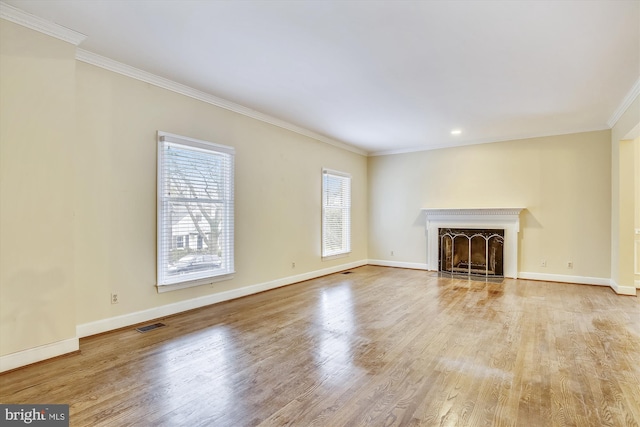 unfurnished living room featuring ornamental molding, baseboards, wood finished floors, a fireplace with flush hearth, and recessed lighting