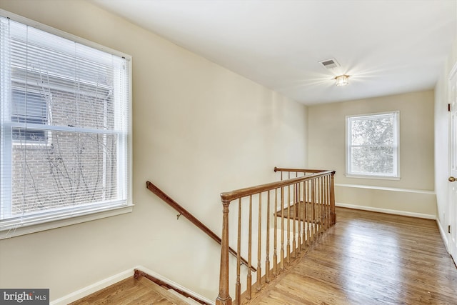 staircase featuring wood finished floors and baseboards
