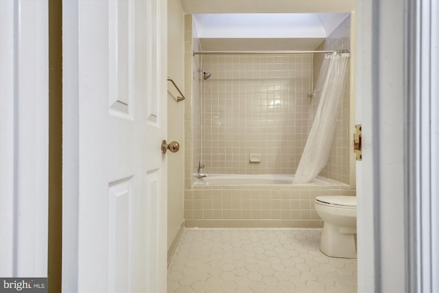 full bathroom with toilet, tile patterned floors, and tiled shower / bath