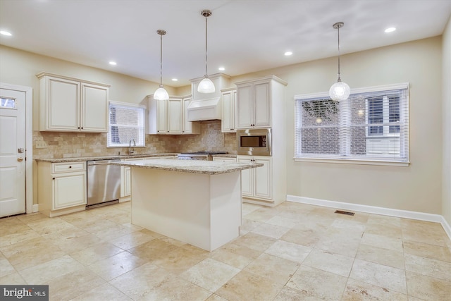 kitchen featuring stainless steel appliances, a sink, tasteful backsplash, a kitchen island, and recessed lighting