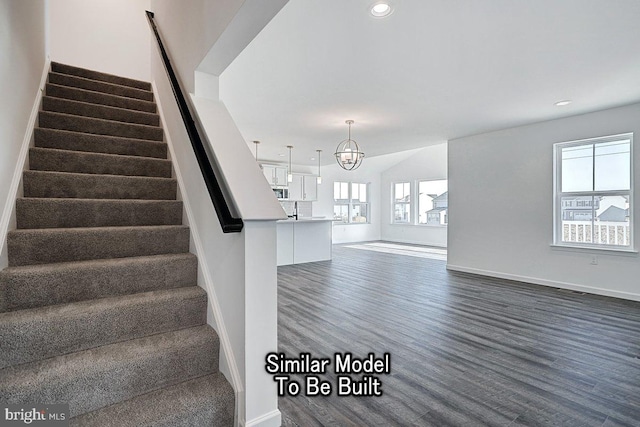stairs with wood finished floors, a chandelier, baseboards, and recessed lighting