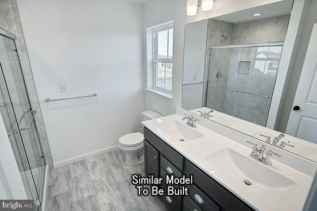 bathroom featuring a shower stall, toilet, baseboards, and double vanity