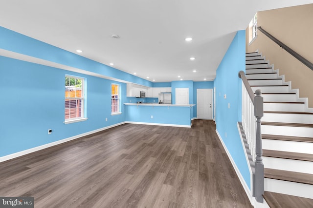 4820 Hayes St NE, Washington, DC 20019 - unfurnished living room featuring dark wood-style flooring, stairway, recessed lighting, and baseboards