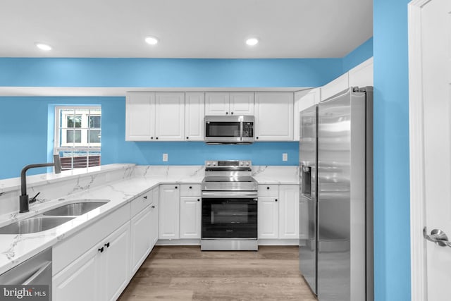 4820 Hayes St NE, Washington, DC 20019 - kitchen with appliances with stainless steel finishes, a sink, white cabinets, light stone counters, and recessed lighting