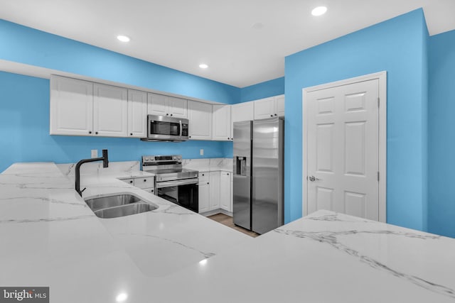 4820 Hayes St NE, Washington, DC 20019 - kitchen with appliances with stainless steel finishes, a sink, light stone countertops, white cabinets, and recessed lighting