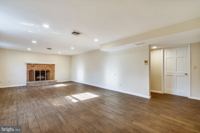 unfurnished living room featuring baseboards, wood finished floors, recessed lighting, and a fireplace