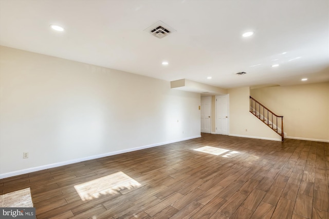 empty room with wood finished floors, baseboards, stairs, and recessed lighting