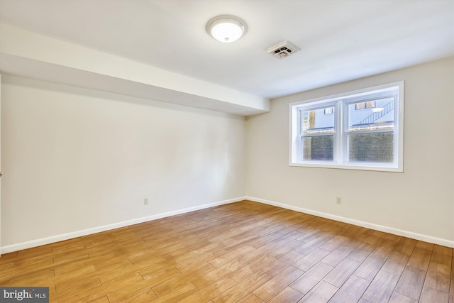 empty room with baseboards and light wood finished floors