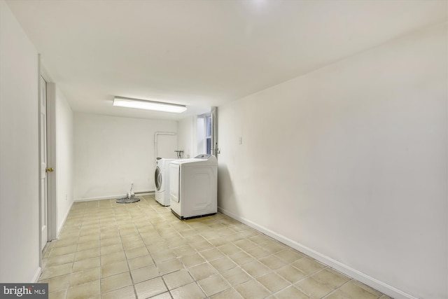 laundry room with washer and dryer, baseboards, and light tile patterned floors