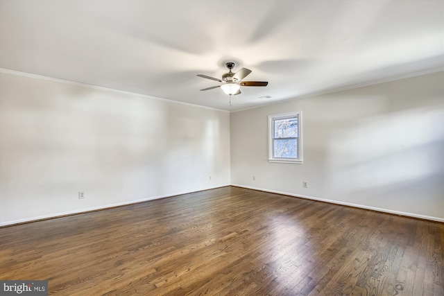 spare room featuring ceiling fan, ornamental molding, dark wood-type flooring, and baseboards