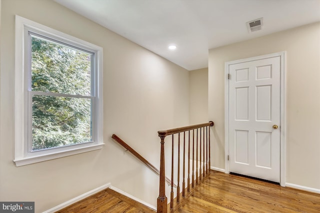 staircase with baseboards, healthy amount of natural light, wood finished floors, and recessed lighting