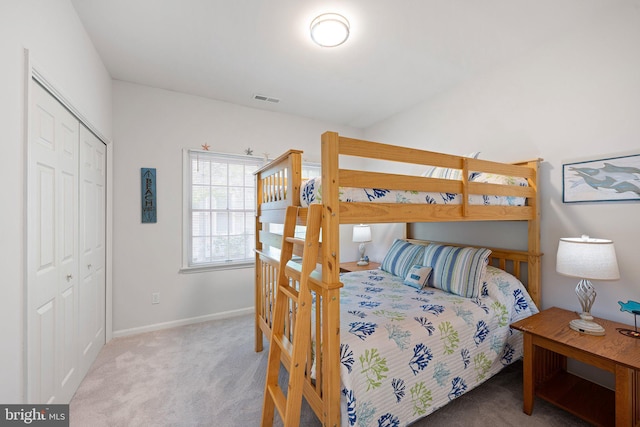 carpeted bedroom with a closet and baseboards