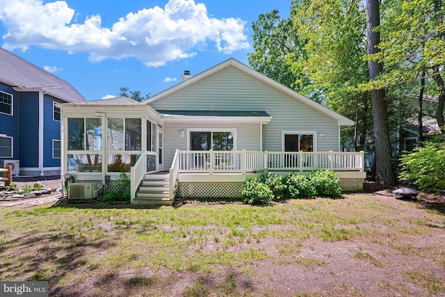 back of house featuring a sunroom, a deck, and a chimney