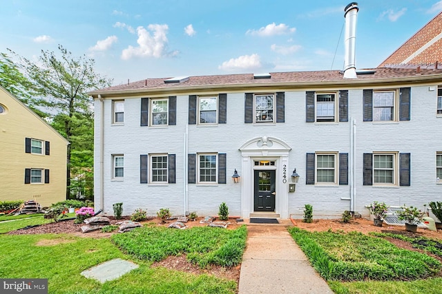 colonial-style house with brick siding