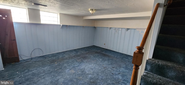 2247 Searles Rd, Baltimore, MD 21222 - basement featuring dark carpet, a textured ceiling, wood walls, and a wainscoted wall
