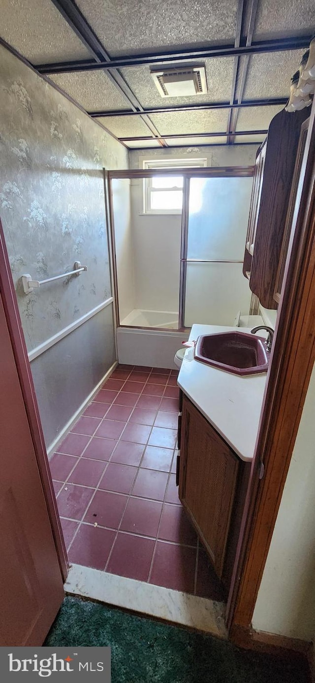 2247 Searles Rd, Baltimore, MD 21222 - full bath featuring vanity, bath / shower combo with glass door, washer / dryer, tile patterned flooring, and toilet