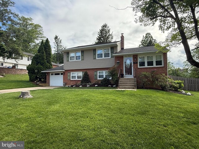 714 Meredith St, Kennett Square, PA 19348 - tri-level home featuring brick siding, driveway, a chimney, and an attached garage