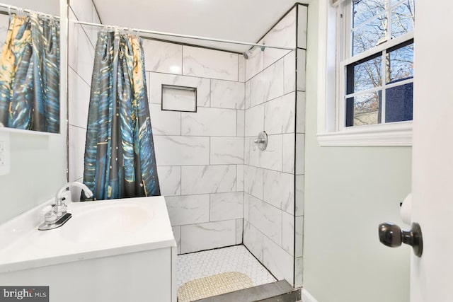 bathroom featuring a tile shower and vanity