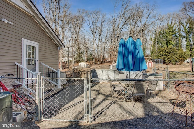 view of patio with a gate, fence, and outdoor dining space