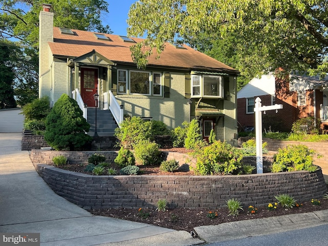 8107 Chester St, Takoma Park, MD 20912 - view of front facade featuring brick siding, a chimney, and roof with shingles