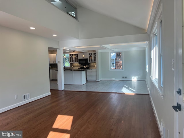 8107 Chester St, Takoma Park, MD 20912 - unfurnished living room featuring baseboards, healthy amount of natural light, wood finished floors, vaulted ceiling, and recessed lighting