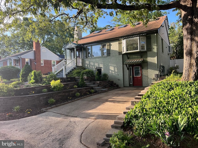 8107 Chester St, Takoma Park, MD 20912 - view of front facade with brick siding, a chimney, and a wall mounted air conditioner