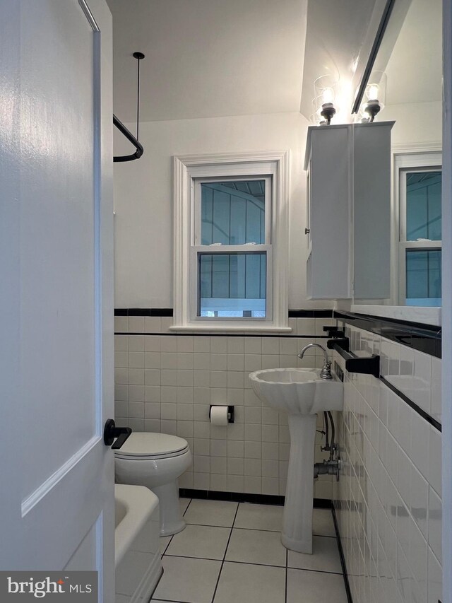 8107 Chester St, Takoma Park, MD 20912 - bathroom with tile walls, tile patterned floors, toilet, wainscoting, and a sink