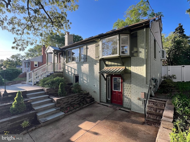 8107 Chester St, Takoma Park, MD 20912 - view of property featuring brick siding, a patio, fence, and a chimney