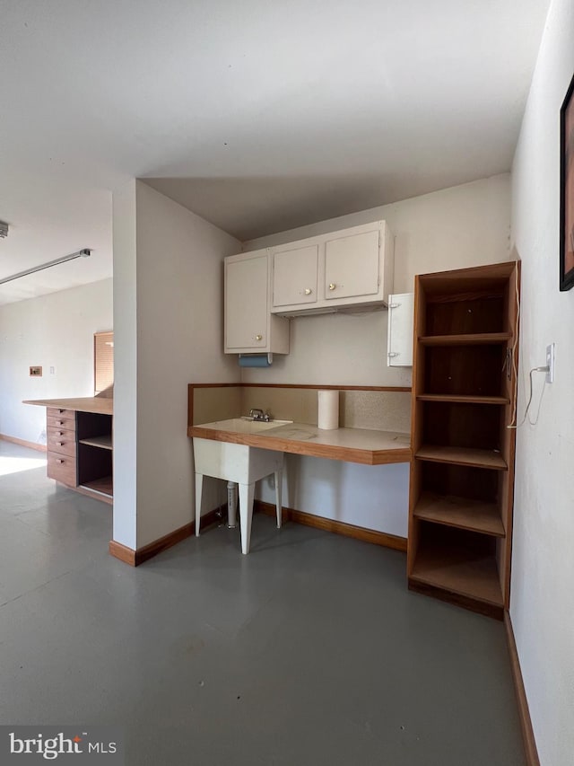 8107 Chester St, Takoma Park, MD 20912 - kitchen with baseboards, concrete floors, white cabinetry, and open shelves