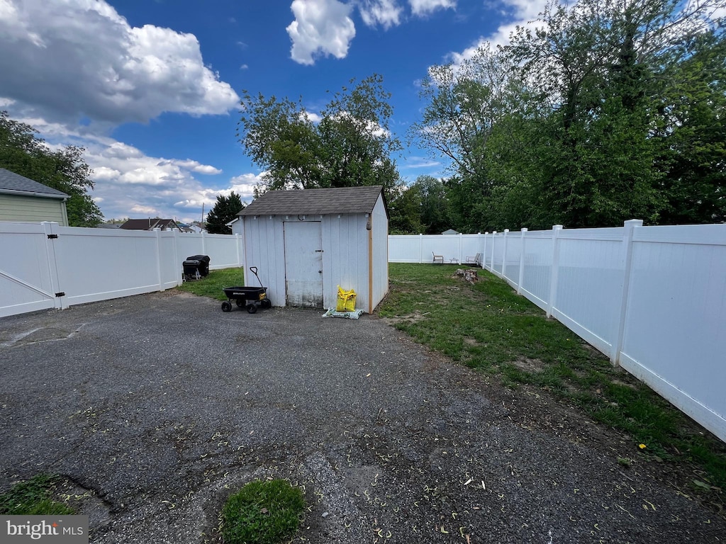 view of yard featuring an outbuilding, a storage unit, and a patio area