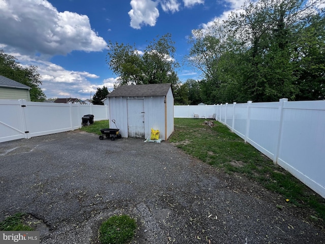 view of yard featuring an outbuilding, a storage unit, and a patio area
