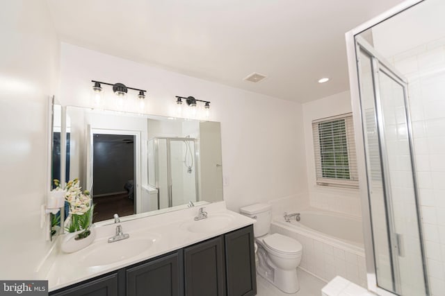 bathroom featuring a stall shower, a garden tub, toilet, double vanity, and tile patterned floors