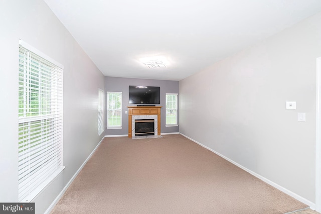unfurnished living room with light carpet and baseboards
