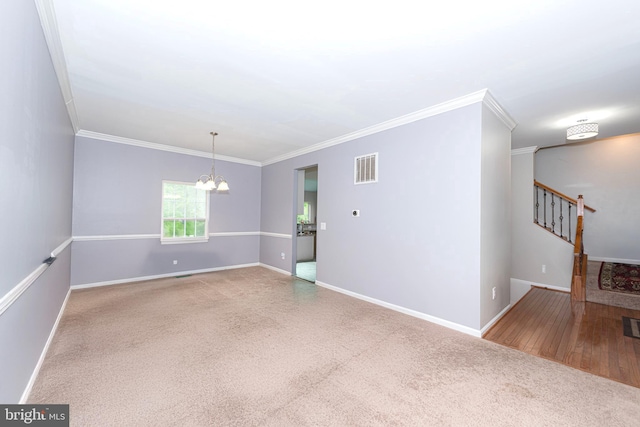 carpeted empty room featuring a chandelier, baseboards, ornamental molding, and stairs