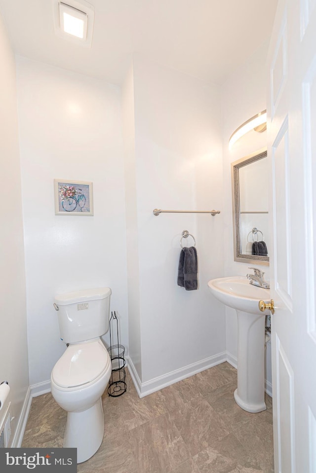 bathroom with toilet, baseboards, and a sink