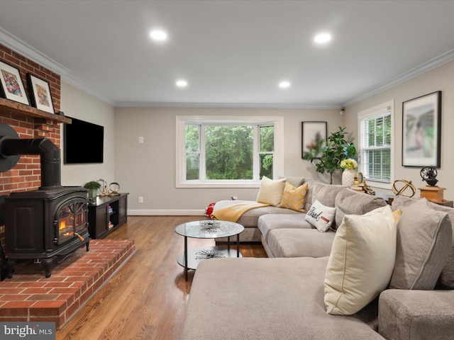 living area featuring a wood stove, ornamental molding, wood finished floors, recessed lighting, and baseboards