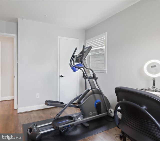 exercise room featuring baseboards and wood finished floors