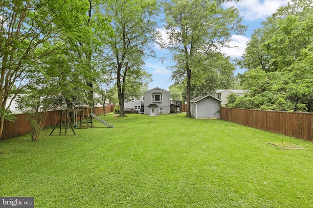 view of yard featuring a storage shed, a playground, and an outdoor structure