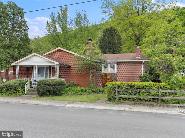 629 W Piedmont St, Keyser, WV 26726 - ranch-style house with brick siding, a chimney, covered porch, and fence