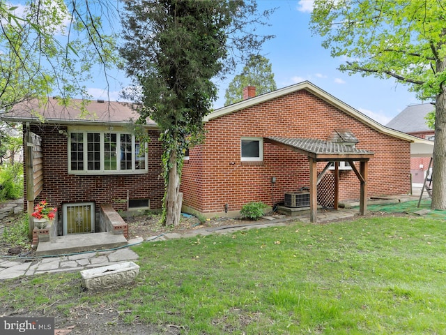 629 W Piedmont St, Keyser, WV 26726 - rear view of property featuring a lawn, central AC, a chimney, and brick siding