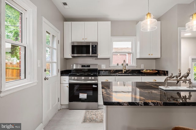 3902 Biddison Ln, Baltimore, MD 21206 - kitchen with appliances with stainless steel finishes, a sink, white cabinets, and plenty of natural light