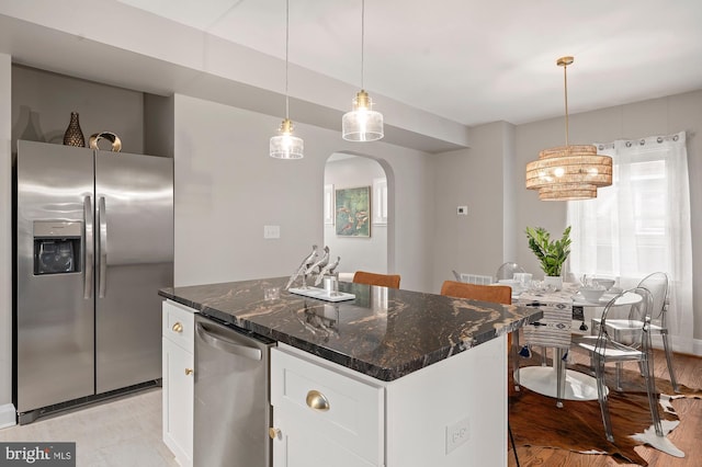 3902 Biddison Ln, Baltimore, MD 21206 - kitchen featuring appliances with stainless steel finishes, white cabinetry, a kitchen island, dark stone counters, and pendant lighting