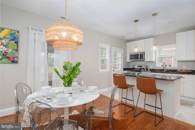 3902 Biddison Ln, Baltimore, MD 21206 - kitchen with appliances with stainless steel finishes, dark countertops, baseboards, and white cabinetry
